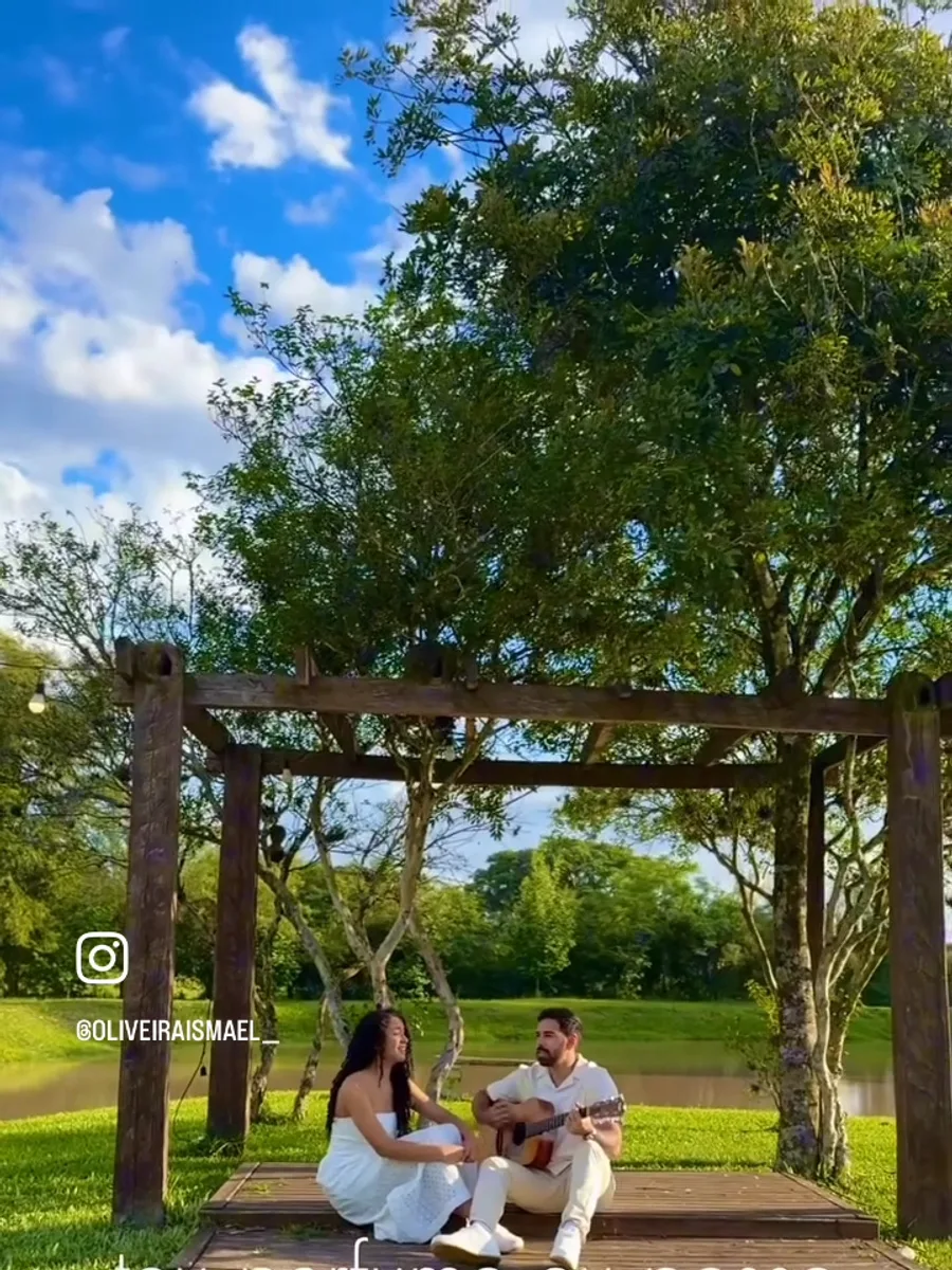 Casal de músicos cantando e tocando violão ao ar livre